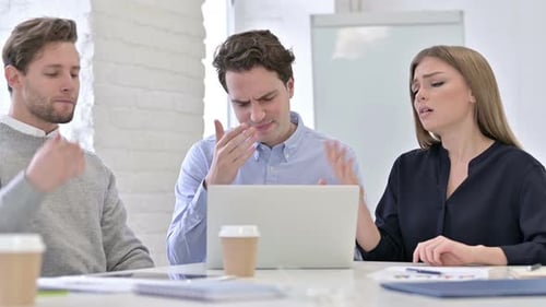 Worried Team Looks at Laptop in Office