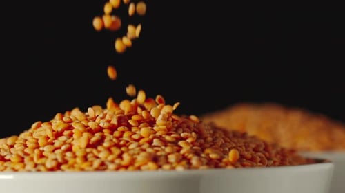 Bright Orange Lentils Poured Into White Bowl