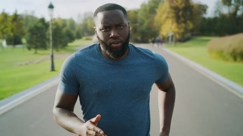 Concentrated Sportsman Jogging on Asphalt Road. Bearded Guy Training Outdoors
