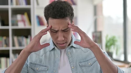 Young Man Massaging Temples Experiencing Headache