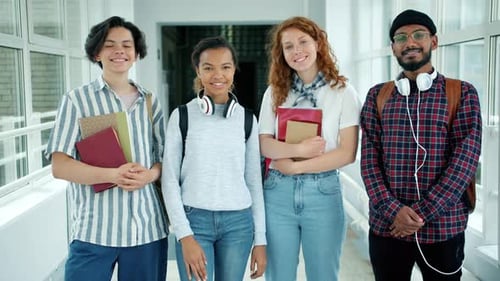 Multi-ethnic Group of People Students Standing in College Hall with Books