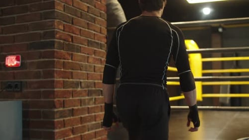Stark fitter Mann geht im Fitnessstudio die Treppe hinauf. Boxer macht sich bereit für den Kampf im Club