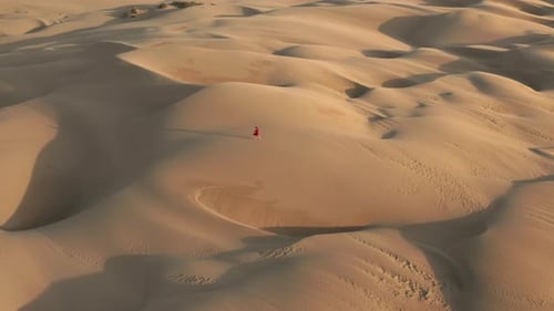 Slow Motion Aerial View of Woman Walking By Sand Dunes at Wild Desert Nature