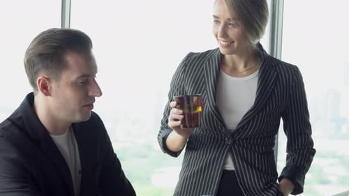 Empresária e empresário se reunindo com um laptop que parece e discutindo juntos.