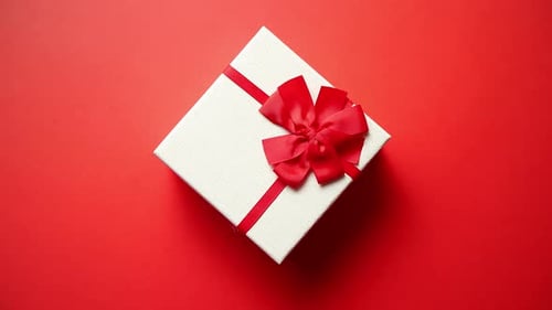 Top View on Gift Wrapped in Striped Gift Paper Decorated with Ribbon on Red