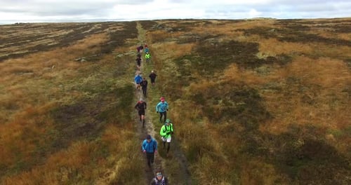 Group Runs a Trail in Rural Grassy Hills