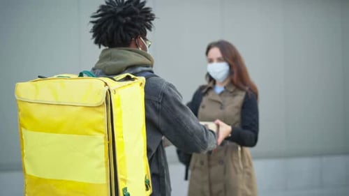 Delivery Person Handing a Package to a Woman