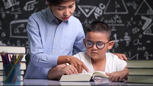 Young Boy Reads Book with Helpful Teacher