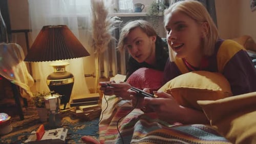 Cheerful Young Couple Playing Retro Console Game and Chatting