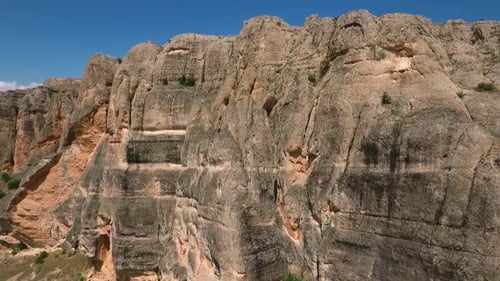 Rugged Mountain Cliff Face Under Blue Skies