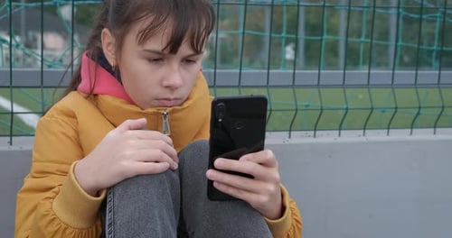 Child Using a Smartphone in an Urban Setting