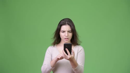 Woman Reacts to Phone Content with Embarrassment