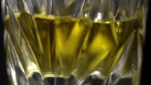 Ice Cubes Added to Liquor in Glass