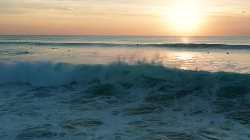 Following large waves at sunset