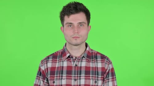 Porträt eines ernsthaften jungen Mannes, der in die Kamera blickt Grüner Chroma-Bildschirm