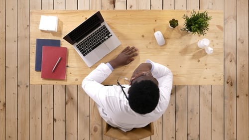 Young doctor at his working place smiling.
