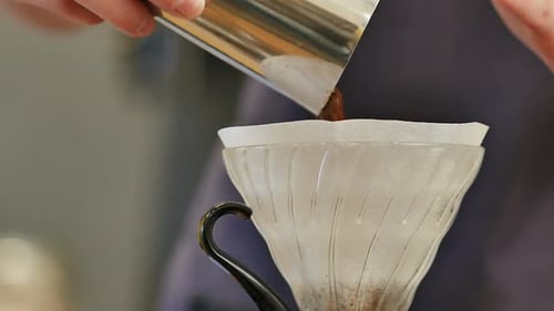 Person Preparing Pour Over Coffee in Glass Filter