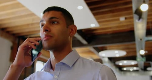 Businessman talking on mobile phone in modern office 4k