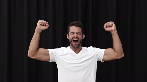 Man Celebrating Success Against Black Backdrop