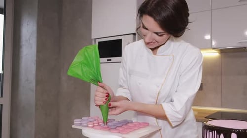 Eine lächelnde Bäckerin macht Macarons