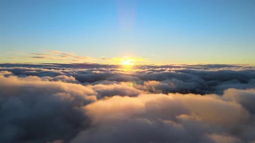 Aerial View From Above at High Altitude of Dense Puffy Cumulus Clouds Flying in Evening