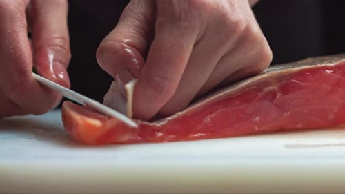 Sushi Chef Slices Fresh Salmon on the Sushi Bar