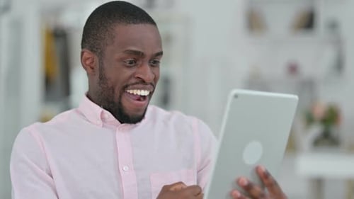 Man Celebrates Good News on Silver Tablet Device