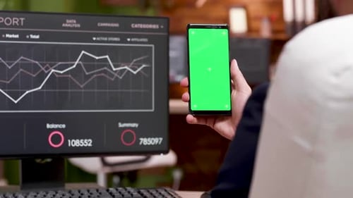 Back View of Caucasian Businessman Holding Mobile Phone with Green Screen.