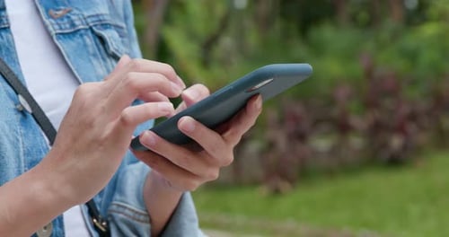 Woman use of mobile phone in city park