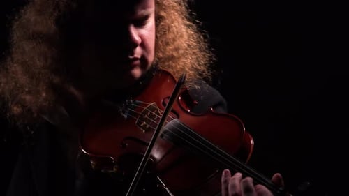 Solo Musician Plays Violin in Dark Studio