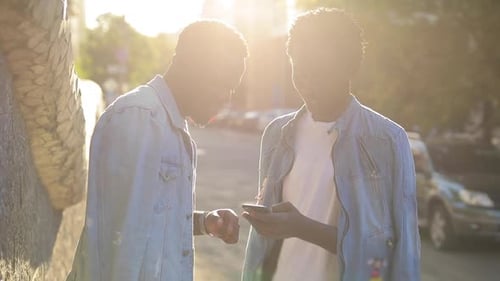 Young Men Laughing at Phone Outdoors