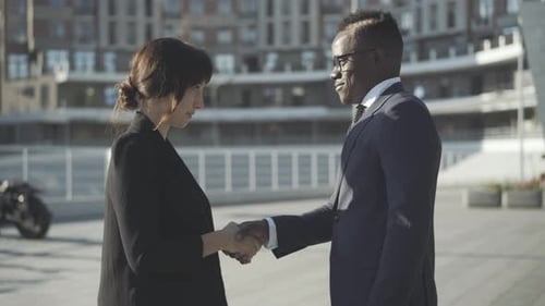 Side View of Multiracial Partners Shaking Hands on Sunny City Street. Handshake of Confident