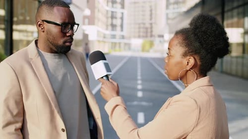Reporter Interviews Man on City Street