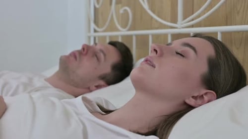 Couple Sleeping Peacefully in Bed at Home