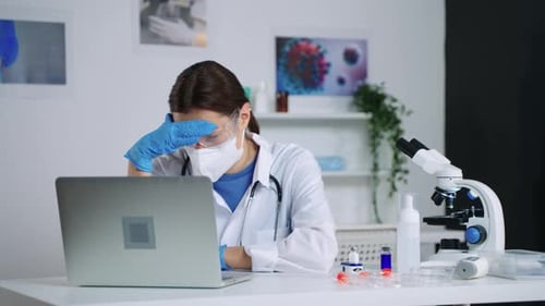 Frustrated Woman Medical Researcher in Lab Using Laptop