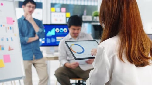 Team Meeting with Data on Tablet in Office
