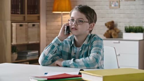 Child Using Smartphone at Desk Indoors