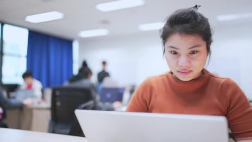 Focused Woman Works on Laptop in Modern Office