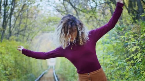 Bonne jeune touriste tournant dans le tunnel de l'amour avec des feuilles d'automne respirant de l'air frais