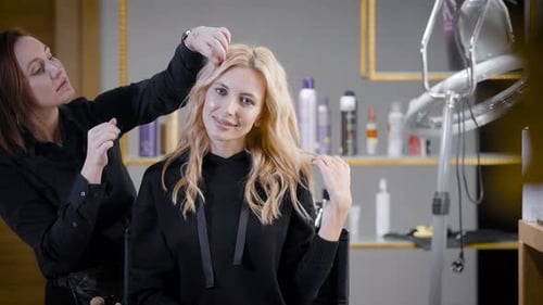 Stylist Arranging Blonde Woman's Hair in Beauty Salon