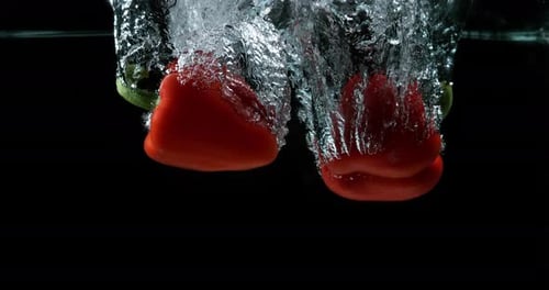 Red Bell Peppers Falling Into Water