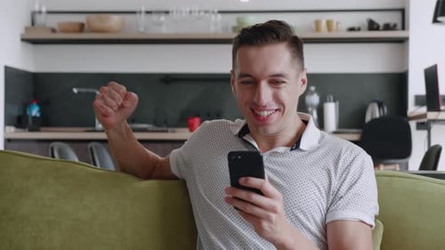Excited Man Celebrating Success Using Mobile Phone