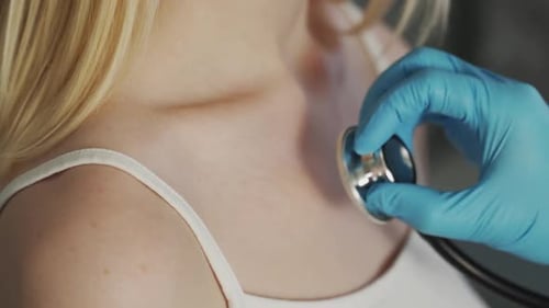 Doctor Checking Young Woman with Stethoscope