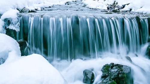 Wonderful Frozen Foot of a Waterfall with a Powerful Stream of Water at Winter Carpathian Mountains