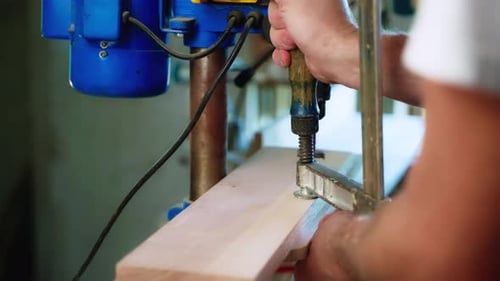 Man Clamping Wood With Drill Press for Woodworking