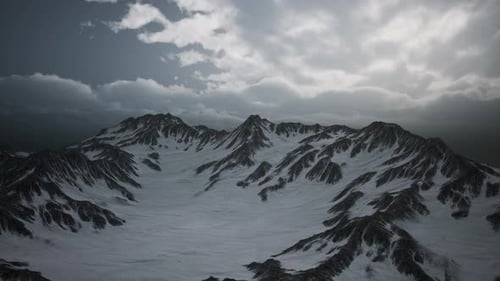 Snowy Mountain Range Aerial View with Dark Overcast Sky