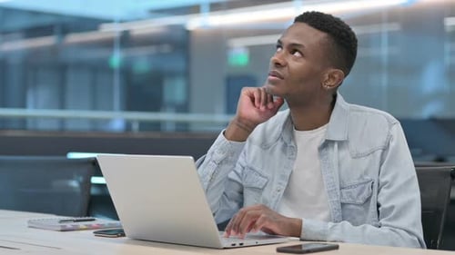 Young Man Typing on Laptop, Thinking