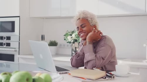 Jovem mulher hispânica feliz apaixonada assistindo filme no laptop na cozinha