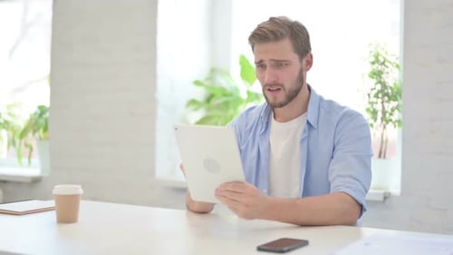 Man Reacts to Disappointing News on Tablet