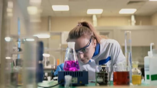 Female Scientist Monitoring Experiment in Bright Laboratory